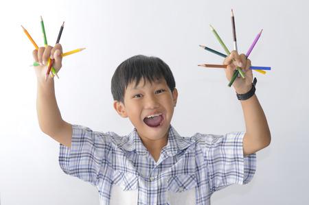 Asian boy is showing his color pencils