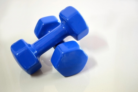 Drumbell. Two blue drumbells in crossed position on the floor for bodybuilding and weight trainingの素材