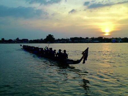 Thai boat racing on river and sunsetの写真素材