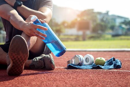 Man runner is holding bottle of water.