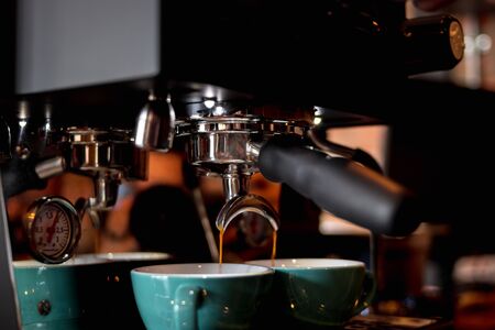 Close up coffee maker machine with coffee cup.