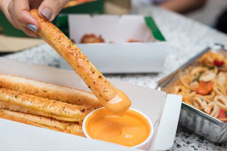 Closeup of woman hand picking bread stick.