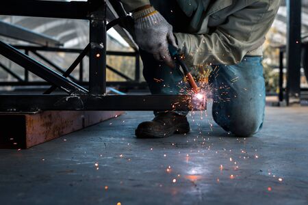 A man welder in uniform is working in workshop.の写真素材