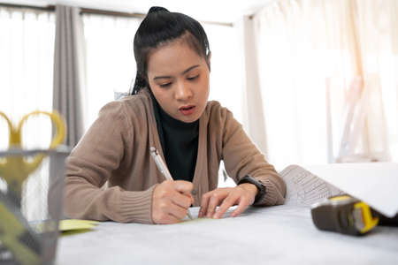Architect or Engineer woman is working at home.