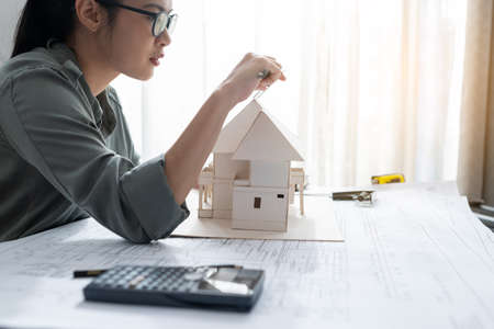 Engineer using Vernier caliper to measuring architectural model.