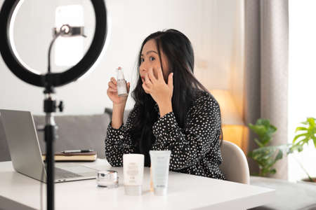 woman blogger showing her cosmetics product by smartphone to live video online. business online concept.の写真素材
