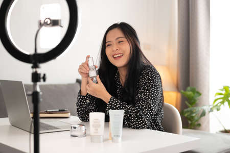 woman blogger showing her cosmetics product by smartphone to live video online. business online concept.の写真素材