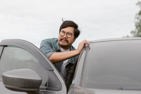 Man driver is pushing his car after car breakdown.の写真素材