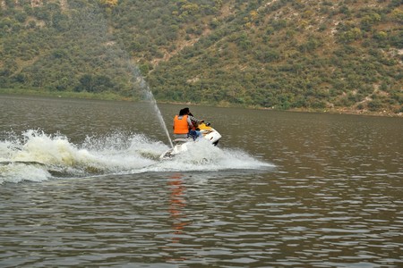 india - rajasthan - alwar - october 20, 2018 two men on jet skye in siliserh lake, water splashes all aroundのeditorial素材