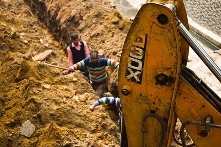 construction by heavy machine, people on the wayの写真素材