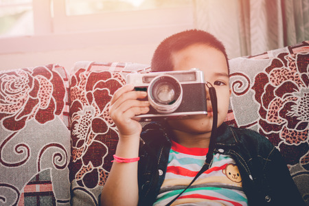 Kid studying photography with old camera  favorite in the house.の写真素材