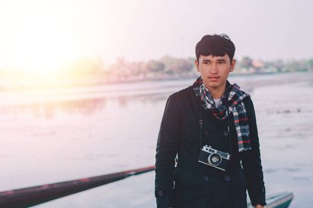 Lifestyle portrait of winter man with vintage camera taking photo.