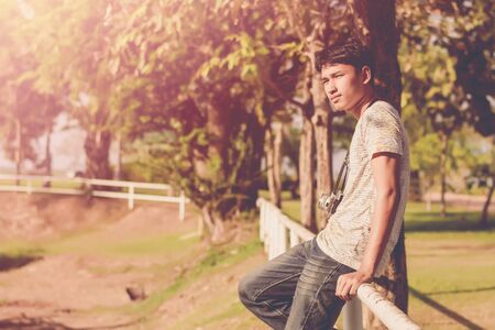 Lifestyle portrait of  young photographer with vintage camera taking photo.の写真素材