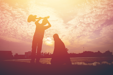 The silhouette of two young men conflict on sunset.の写真素材