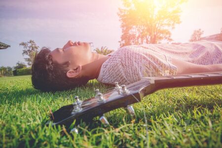 Young hipster man playing guitar to relaxing on his holiday, enjoy with natural and fresh air.
