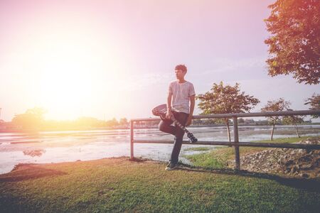 Young hipster man playing guitar to relaxing on his holiday, enjoy with natural and fresh air.