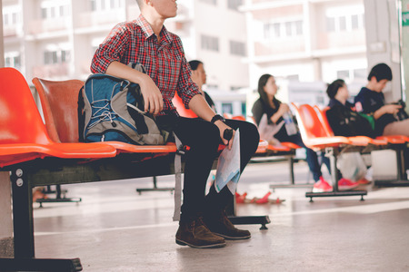 young man waiting time for travel in bus station.の写真素材