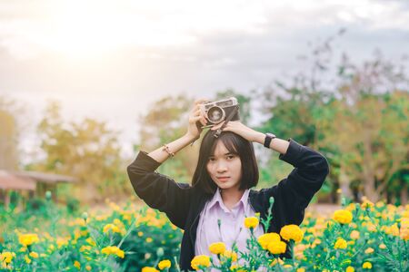 beautiful women with vintage camera in the flower garden.の写真素材