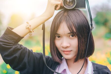 beautiful women with vintage camera in the flower garden.の写真素材