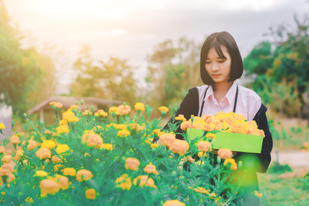 Beautiful girl with flowers in the gardenの写真素材