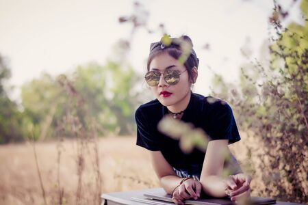 Fashion pretty young woman model in hipster style with vintage piano,fashion black glasses.の写真素材