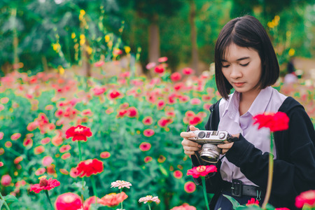 beautiful women with vintage camera in the flower garden.の写真素材