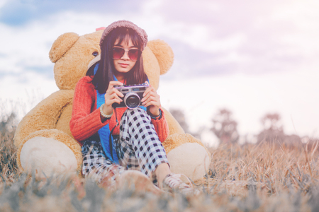 Hipster woman photography with a teddy bear in the winter on the park.の写真素材