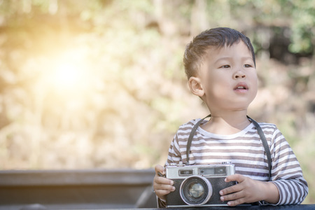 Children (boy) holding a vintage camera.の写真素材