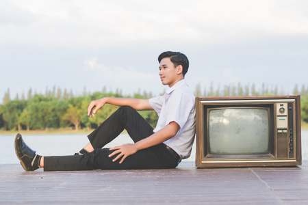 Businessman with vintage tv in nature.の写真素材