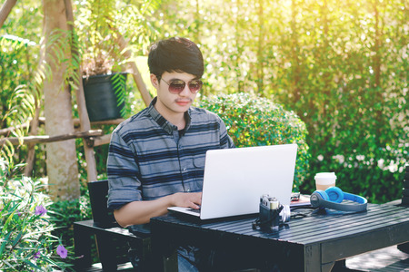 Young businessman working on laptop at garden.の写真素材