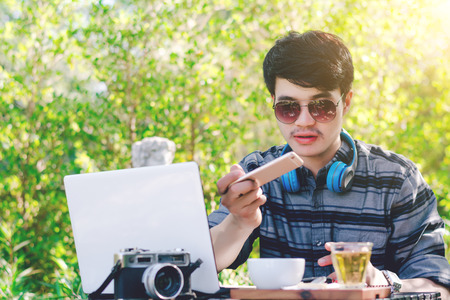 Young businessman working on laptop at garden.の写真素材
