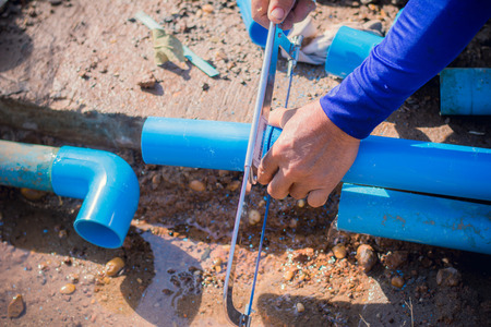 Construction worker,Repairing a broken water pipe on the concrete road.の写真素材