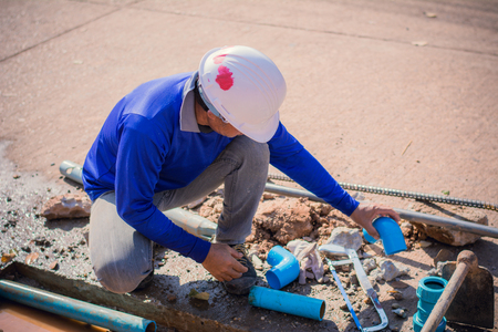 Construction worker,Repairing a broken water pipe on the concrete road.の写真素材