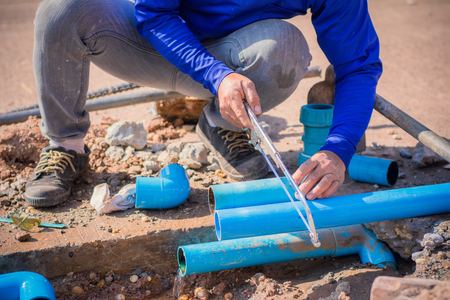 Construction worker,Repairing a broken water pipe on the concrete road.の写真素材