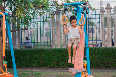 Boy with exercise machines in the parkの写真素材