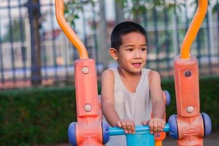Boy with exercise machines in the parkの写真素材