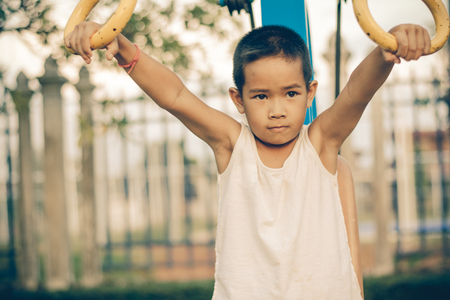 Boy with exercise machines in the parkの写真素材