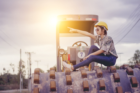 Female engineer with construction worker and steamroller, road construction concept.の写真素材