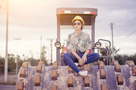 Female engineer with construction worker and steamroller, road construction concept.