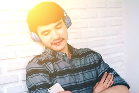 Young hipster gay man listening music headphones.の写真素材