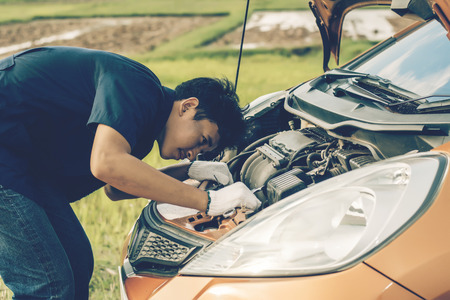 Car mechanic repairing a car engine.の写真素材