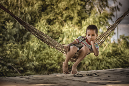 Little boy unhappy sitting alone on abandoned temporary housing.の写真素材