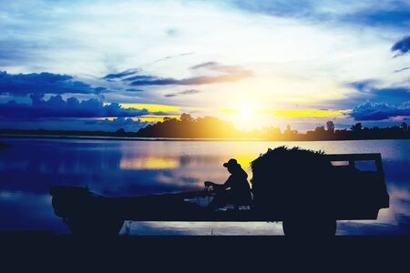 silhouette of farm tractor on sunsetの写真素材