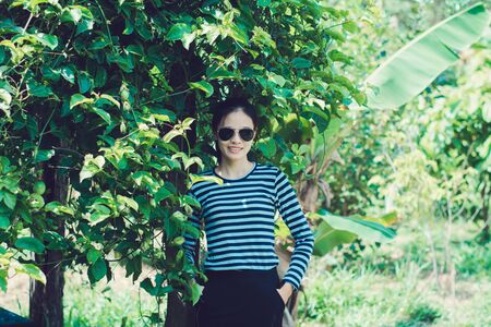 Woman Hipster with sunglasses Fashion Style Lifestyle Concept, wearing a black and white striped t-shirt.の写真素材