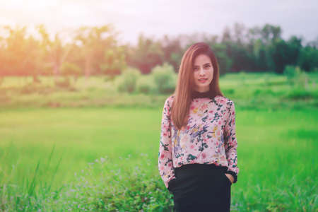 Hipster woman wearing floral shirt , She standing with  a nature background on sunset.の写真素材