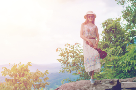 Asian beautiful girl dressed vintage with ukulele in the natural background.の写真素材