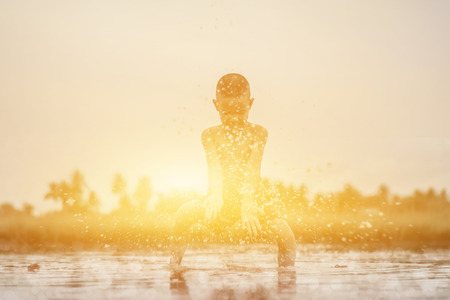 Asian Boy playing in water loosen hot looks happy, Before sunset background ,Thailand.の写真素材