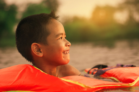 Kid playing water,happy time in the lake at sunset.