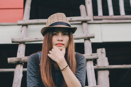 Hipster woman wearing  brown hat and jeans,in a cows farm.の写真素材