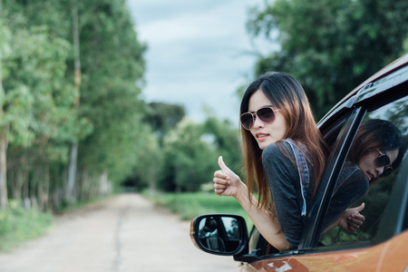 Happy young woman looking out of car window,Toward adventure,relaxing and enjoying road trip.の写真素材